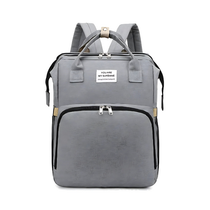 Diaper bag backpack in use as a portable bed with a baby safely resting inside the changing station.