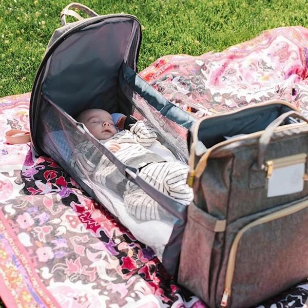 Waterproof diaper bag backpack featuring a portable changing station and bassinet