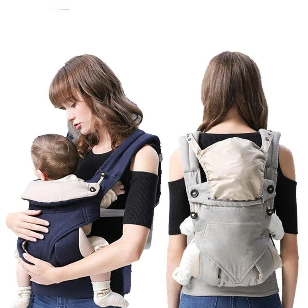 Parent holding infant in a black ergonomic baby carrier with adjustable, padded straps