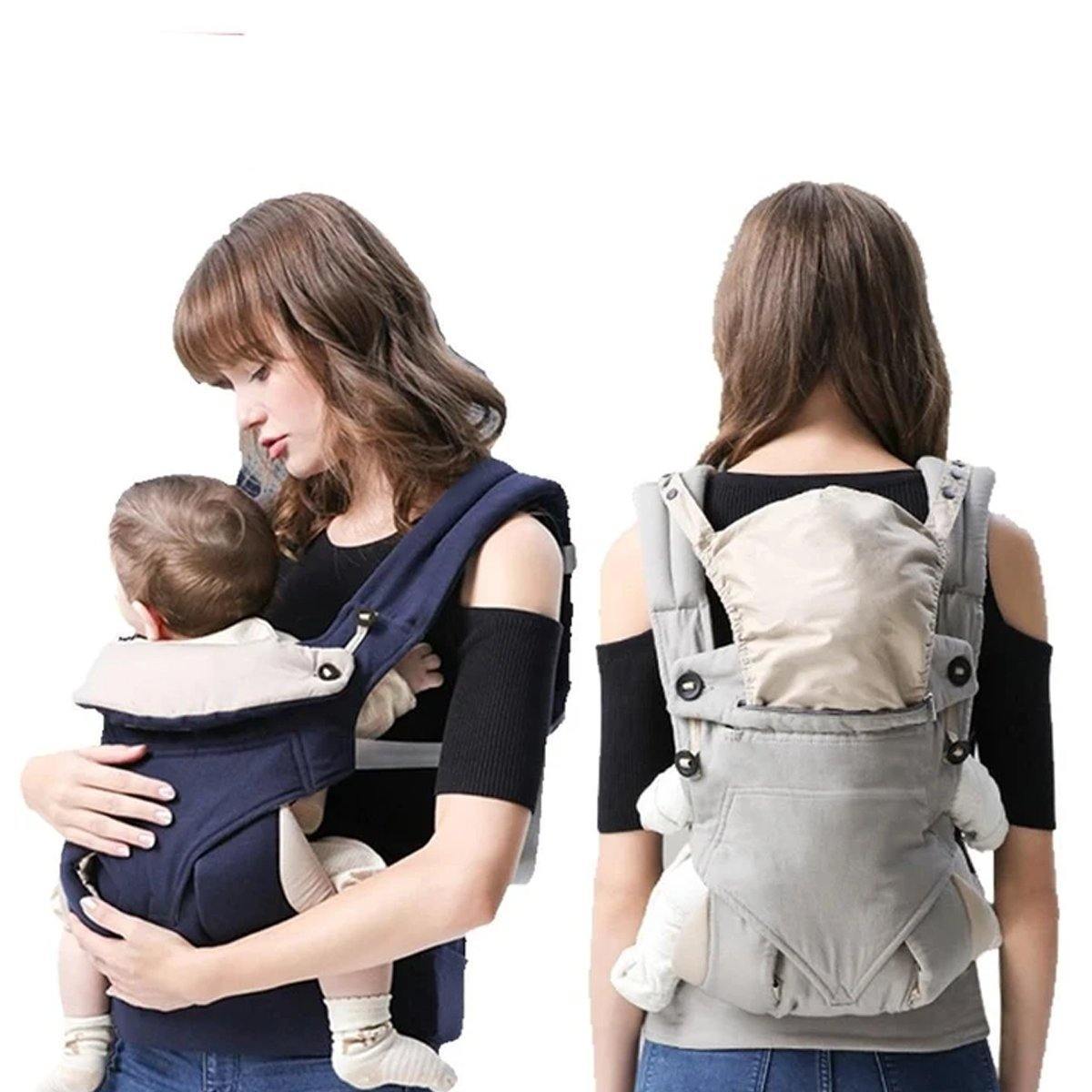Parent holding infant in a black ergonomic baby carrier with adjustable, padded straps