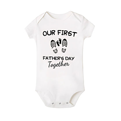 Smiling dad holding baby, both in 'First Father's Day' matching outfits, ideal fathers day gift