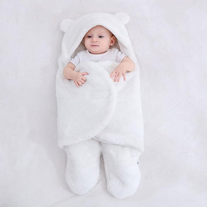 Newborn wrapped snugly in a cozy fleece bear ear swaddle blanket, peaceful sleep.