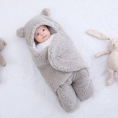 Infant sleep swaddle blanket with adorable bear ears, made from plush fleece material.