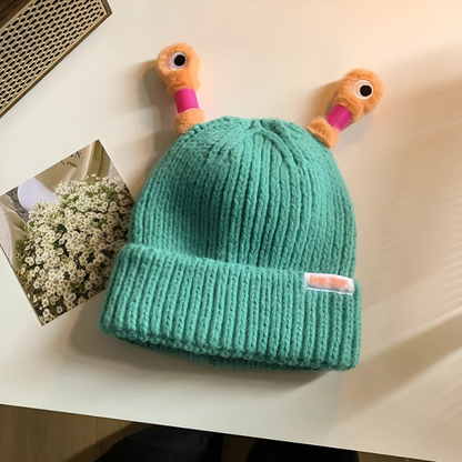 Child playing in the snow wearing a Fun Monster Glowing Knit Hat, warm and playful winter hat