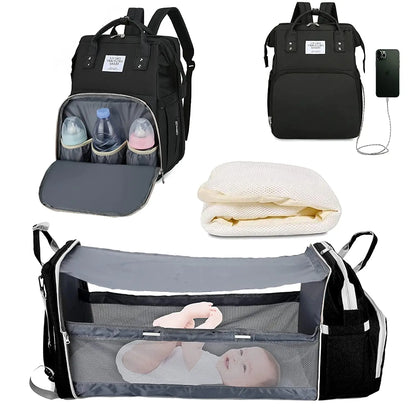 Unisex gray diaper bag backpack unfolds into portable baby bed, ideal for travel and naps on the go