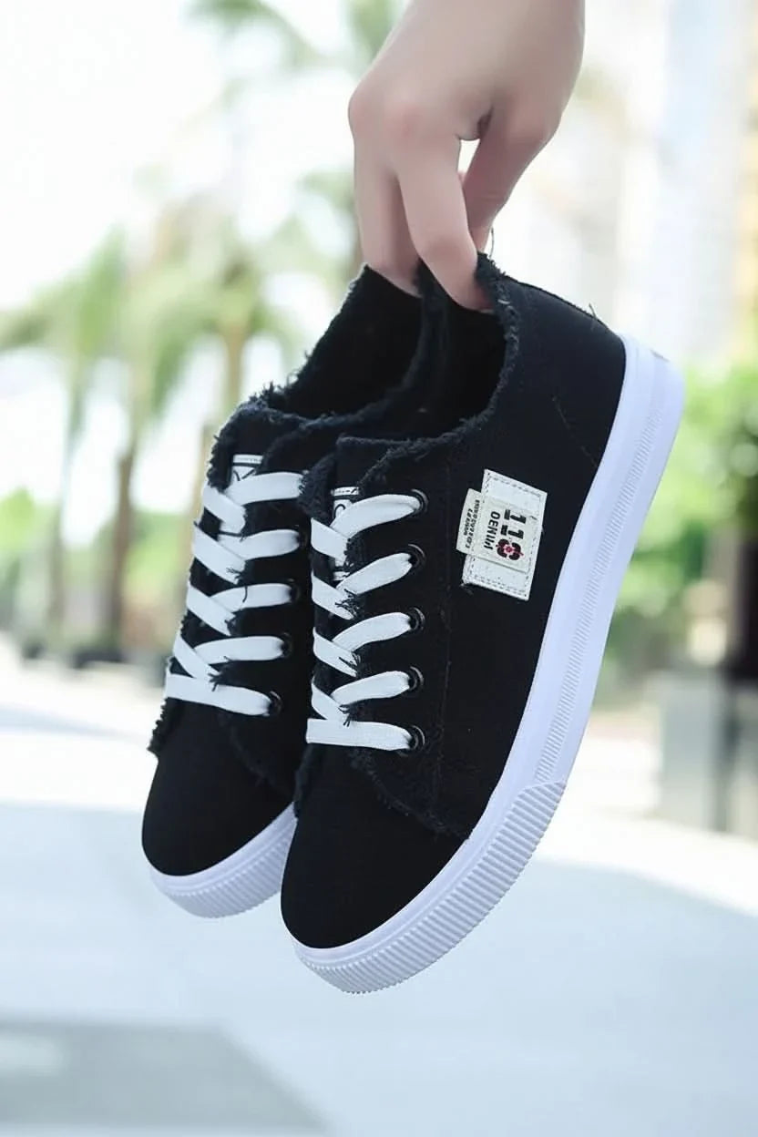 Detailed view of black laces on a classic unisex high-top sneaker, highlighting secure fit and casual fashion.