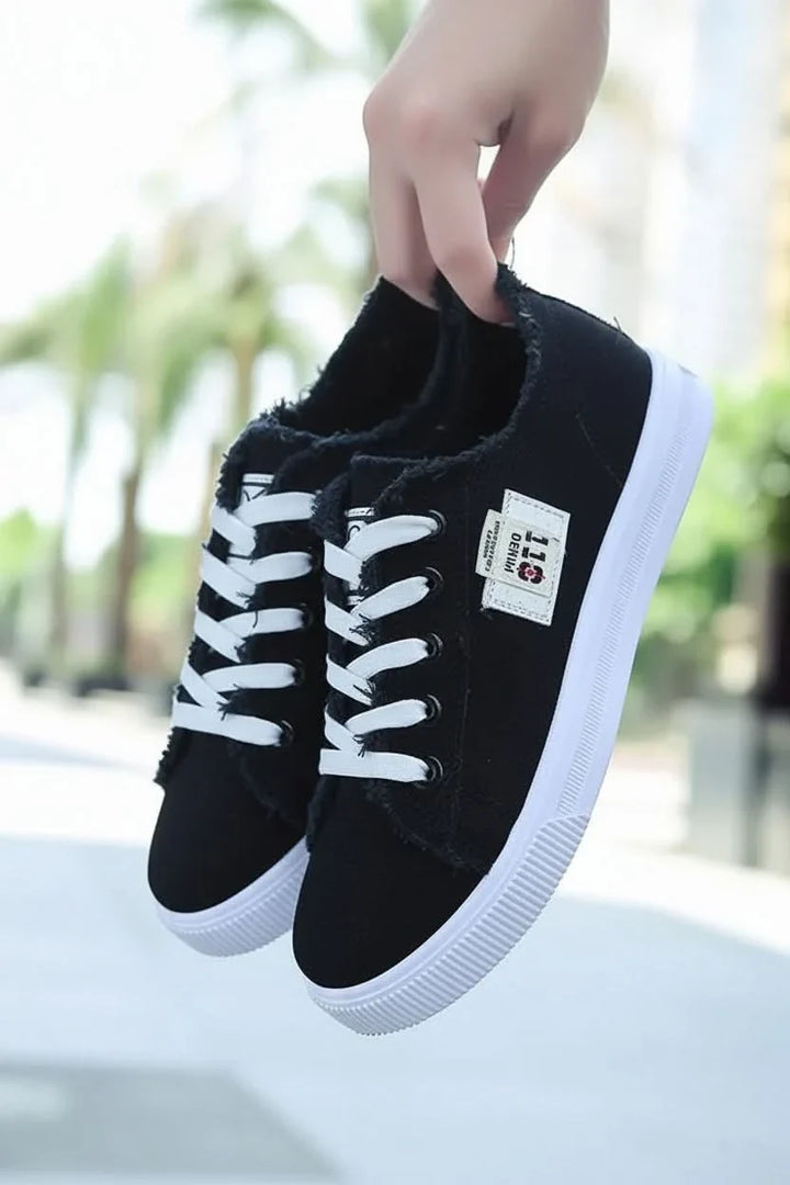 Detailed view of black laces on a classic unisex high-top sneaker, highlighting secure fit and casual fashion.