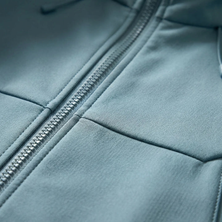 Close-up of the windproof & water-resistant fabric on a unisex hooded soft-shell outdoor jacket.
