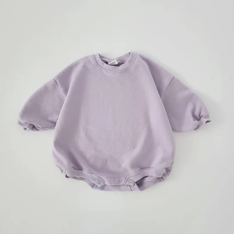 Close-up of the ribbed cuffs and hem on a quality cotton infant romper, secure fit