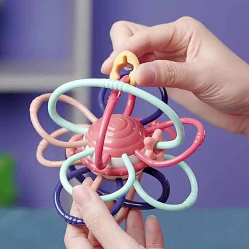 Baby's hands holding a BPA-free rattle teether ball, a developmental toy for infants