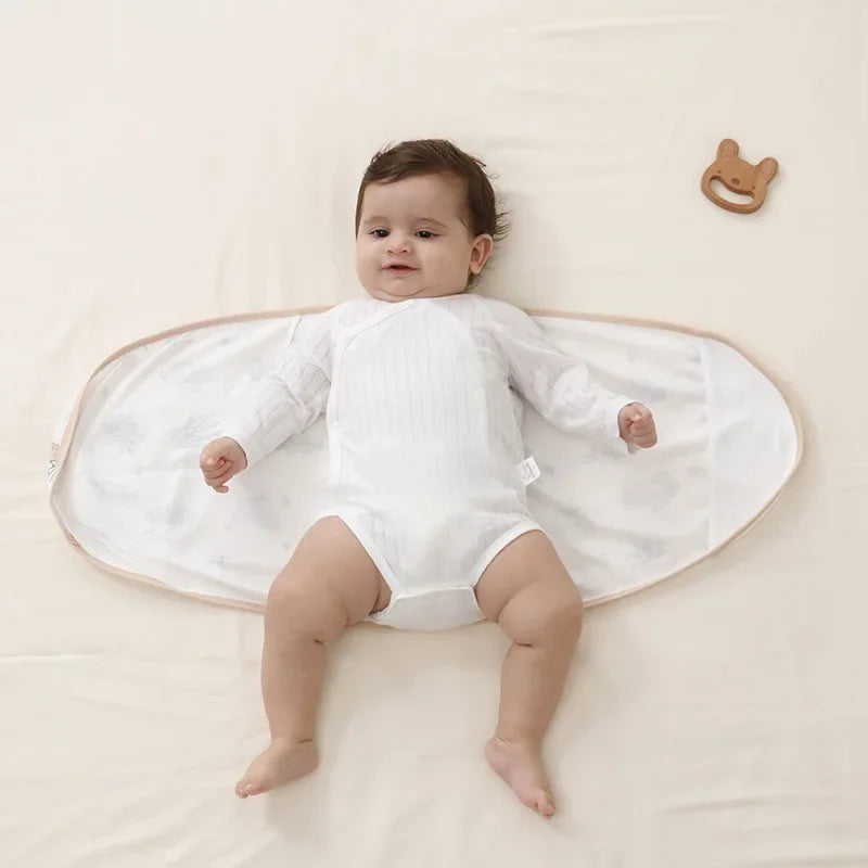 Newborn swaddle blanket in a subtle beige, providing belly protection and cozy baby sleep