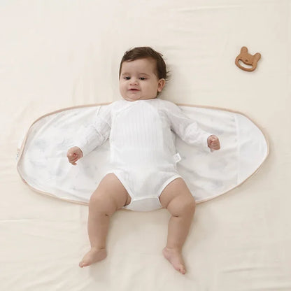 Newborn swaddle blanket in a subtle beige, providing belly protection and cozy baby sleep