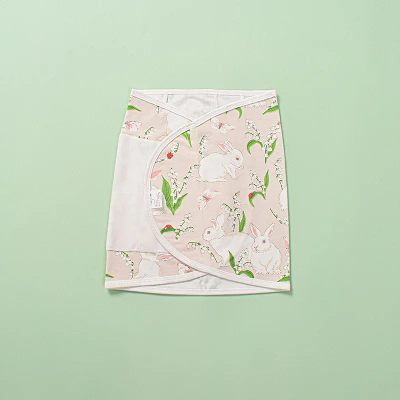 Unisex baby swaddle in a charming polka dot pattern, ideal infant wrap for secure belly comfort