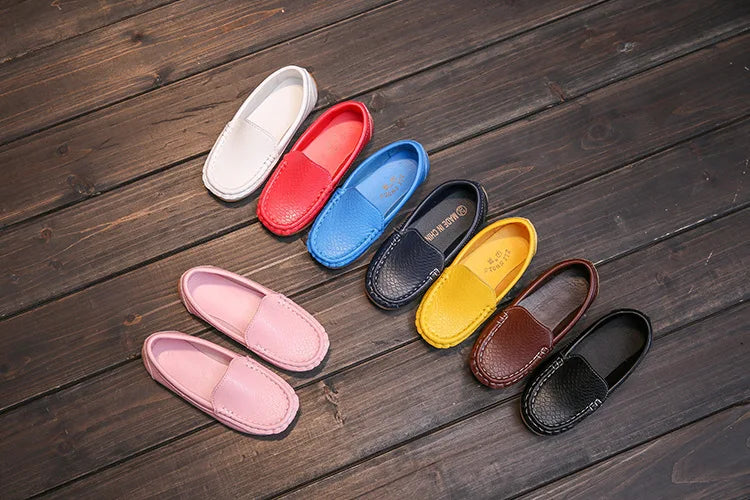 Stack of colorful unisex kids' breathable slip-on loafers. Stylish and practical children's shoes.