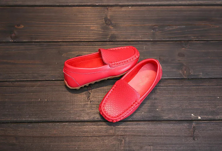 Unisex kids' slip-on loafers worn by a child running, showcasing flexibility. Breathable, anti-slip.