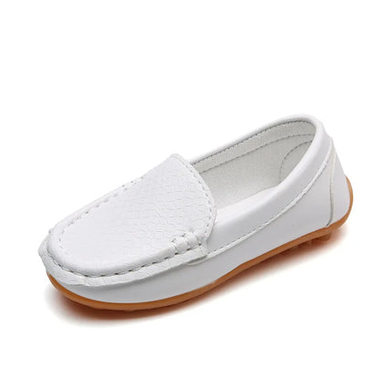 A child sitting and wearing unisex breathable slip-on loafers. Casual and comfortable children's footwear.