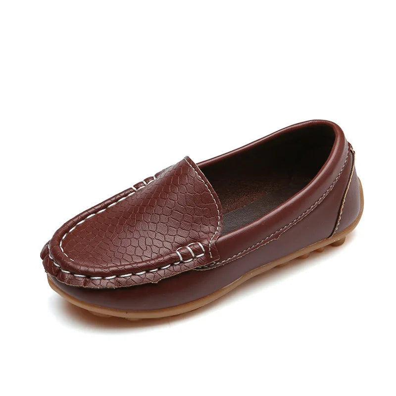 Pair of unisex kids' slip-on loafers displayed on a wooden floor. Breathable, anti-slip for toddlers.