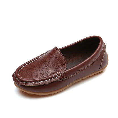 Pair of unisex kids' slip-on loafers displayed on a wooden floor. Breathable, anti-slip for toddlers.