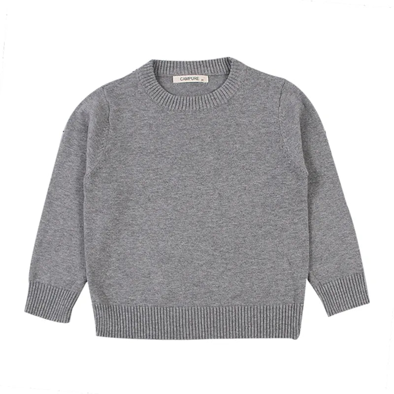 Child playing outdoors wearing a warm unisex cable knit pullover