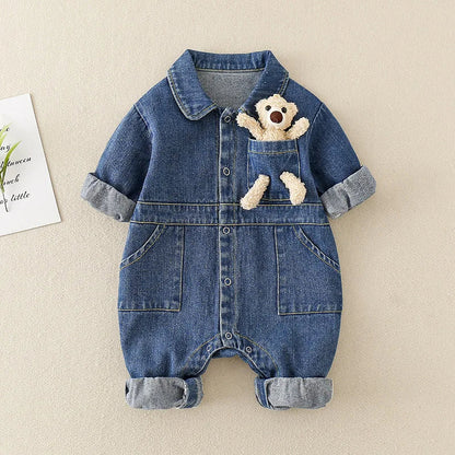 Cute baby wearing a unisex denim jumpsuit, side view, showing practical snaps and flexible design for active toddlers.