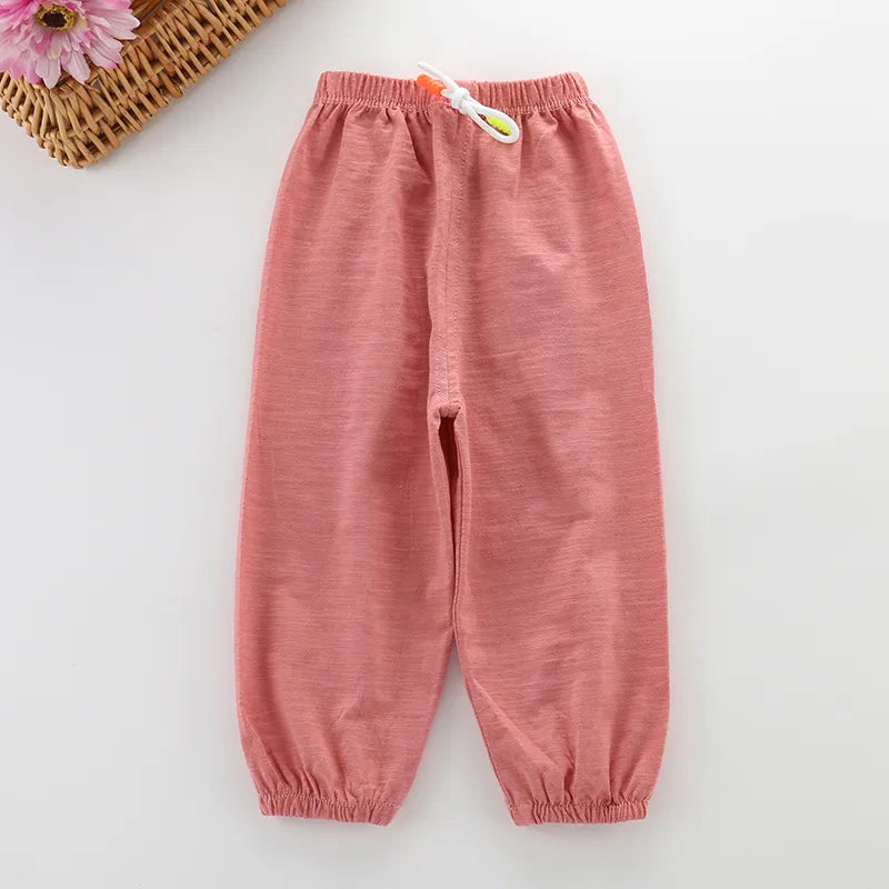 Boy wearing unisex cotton summer pants, light beige, exploring garden, flexible and robust