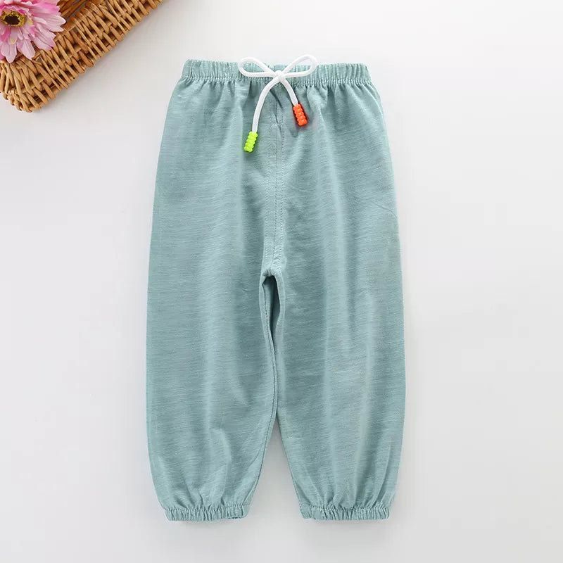 Little girl wearing pink unisex cotton breathable summer pants, playing with toys, comfy fit