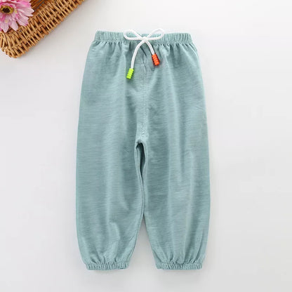 Little girl wearing pink unisex cotton breathable summer pants, playing with toys, comfy fit