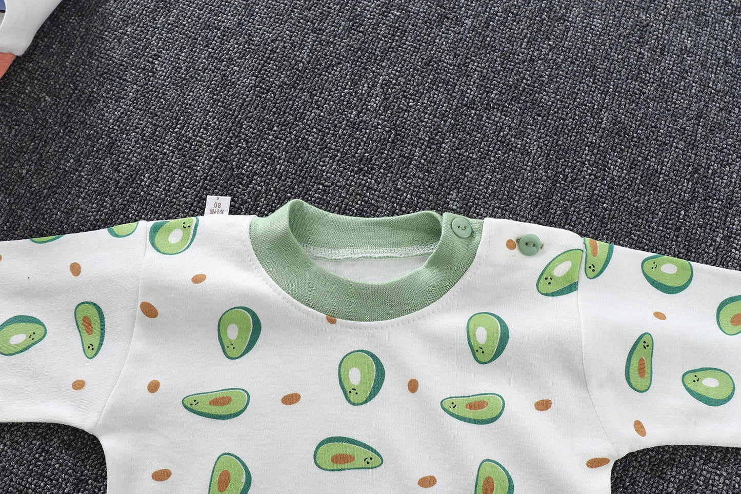 Stack of folded unisex kids' cartoon pajama sets, showcasing various playful designs