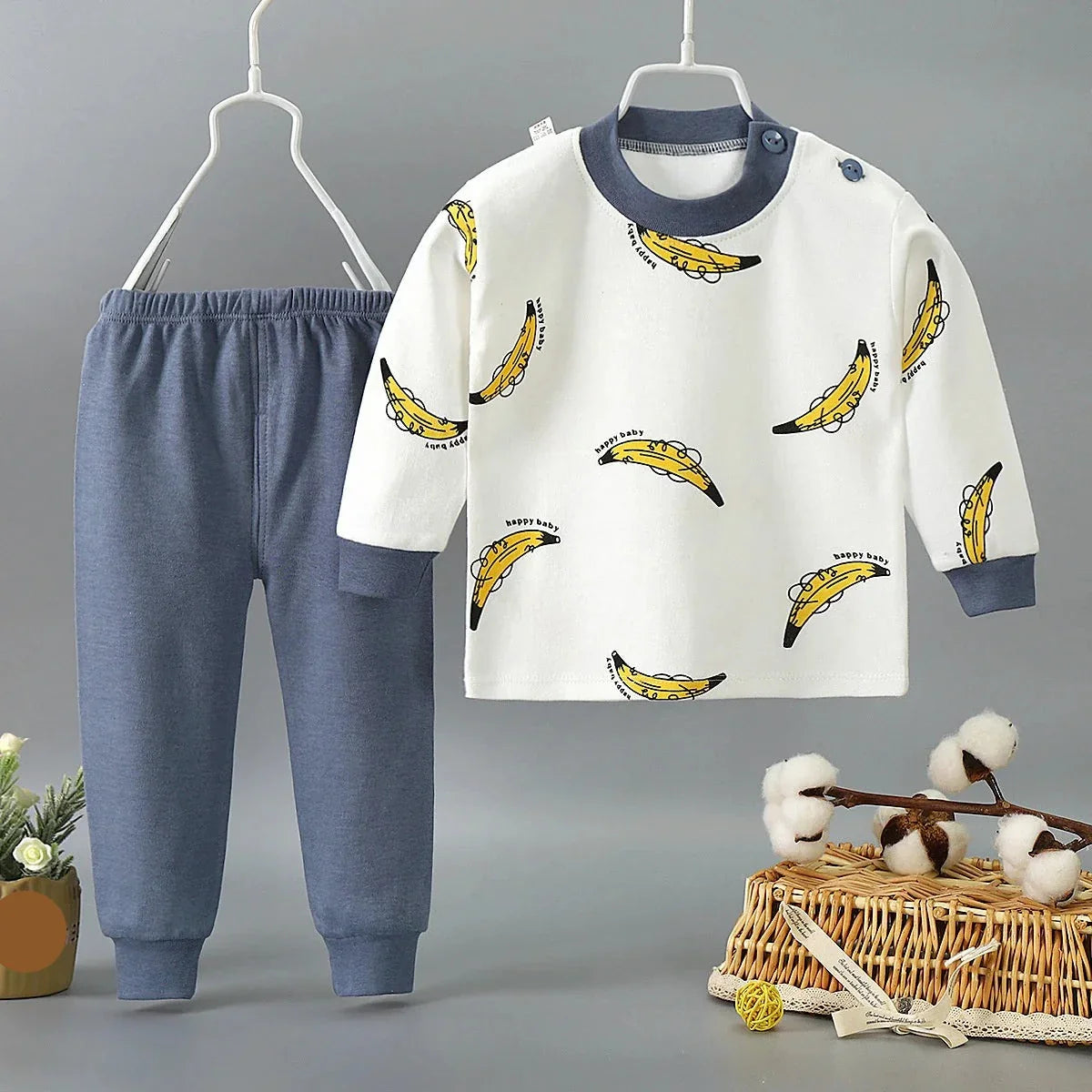 Flat lay of a complete kids' pajama set, showing cartoon print and cotton fabric details