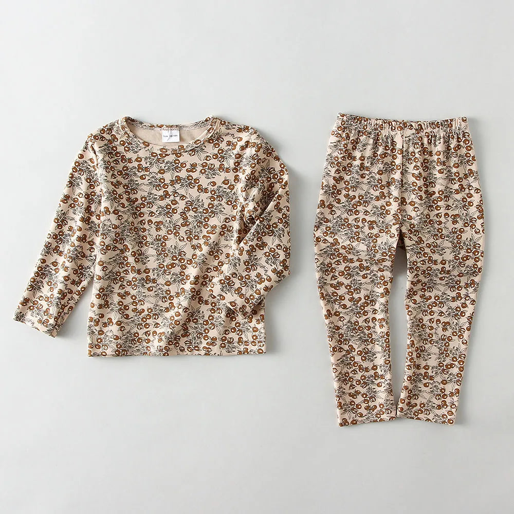 Flat lay of a complete children's cotton sleepwear set, including long-sleeve top and matching pants.