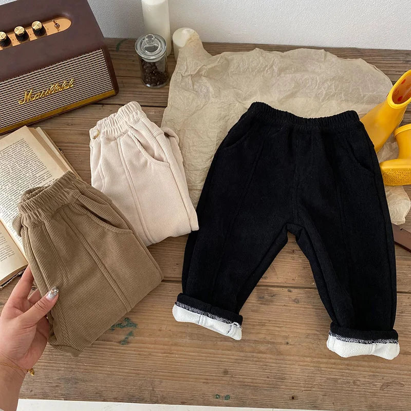 Folded stack of unisex kids warm fleece-lined corduroy pants, various sizes