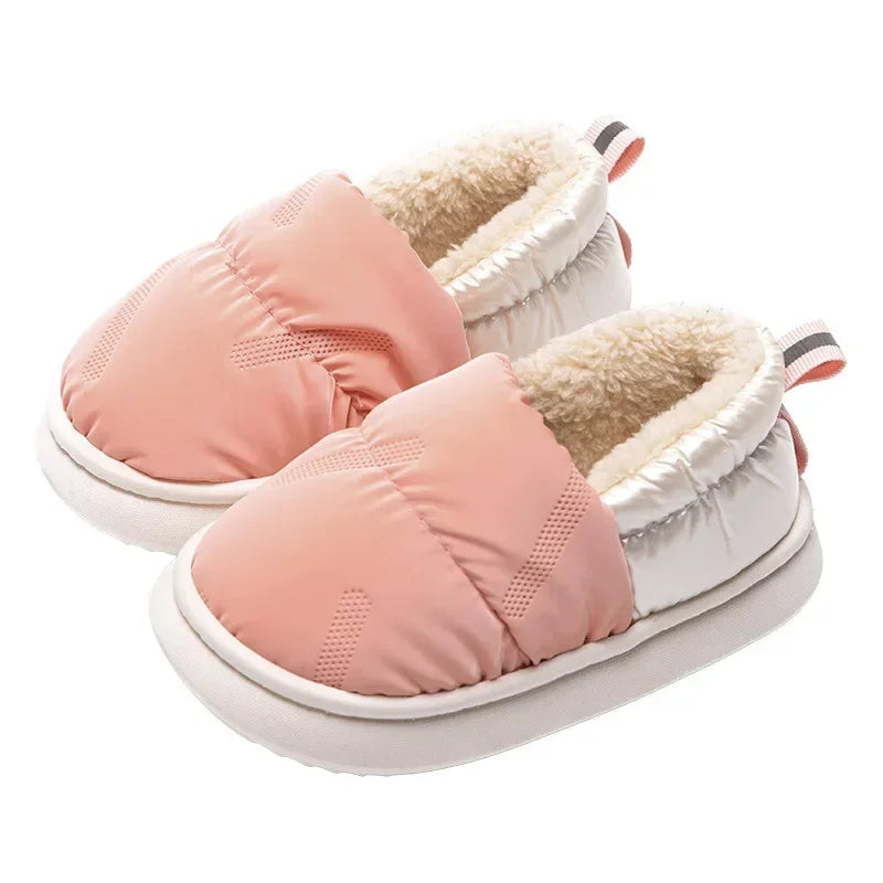 Children's plush fleece slippers in a neutral color, featuring a textured anti-slip sole for secure indoor play.
