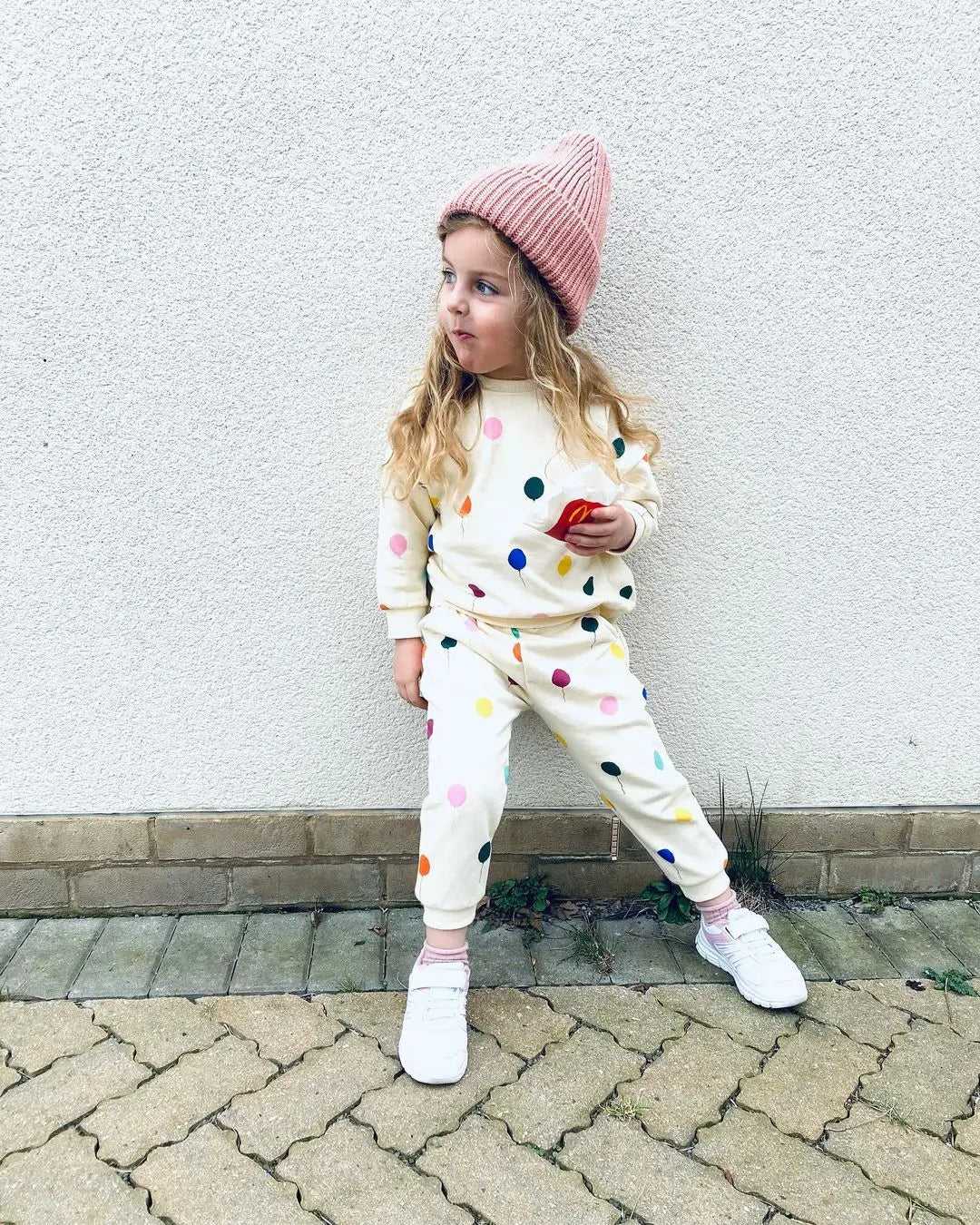 Side view of a child in a long-sleeve hooded cotton outfit, ideal for everyday wear