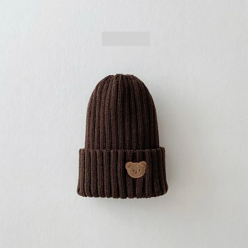Unisex baby accessory: warm knitted beanie hat with a detailed bear embroidery, winter essential.