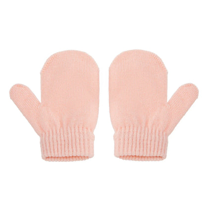 Close-up of a knitted pompom winter hat and gloves set, showing texture and detail