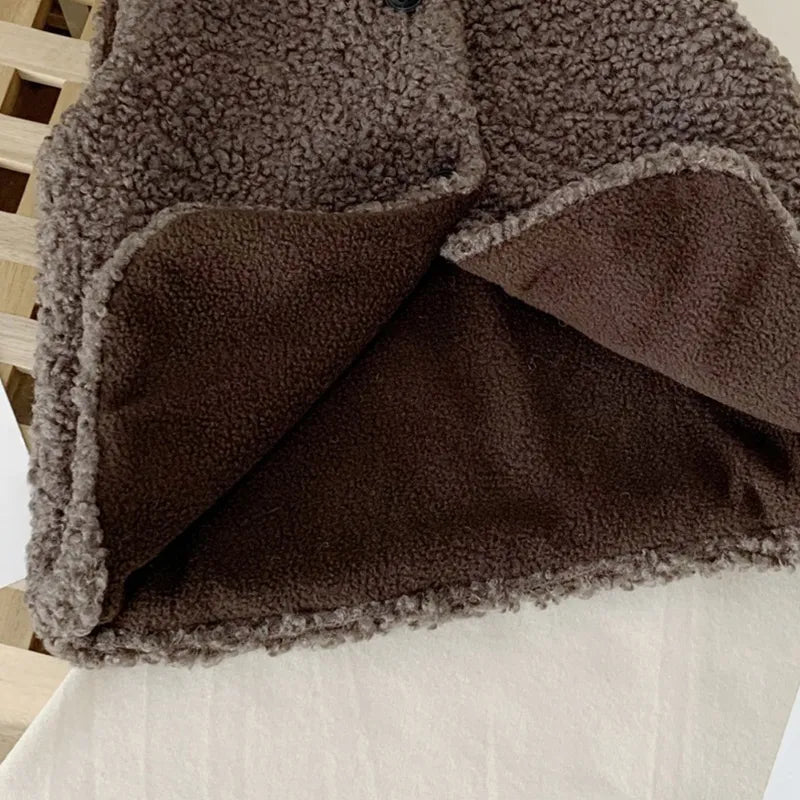 Toddler boy playing in a warm lamb wool vest, stylish unisex baby outerwear