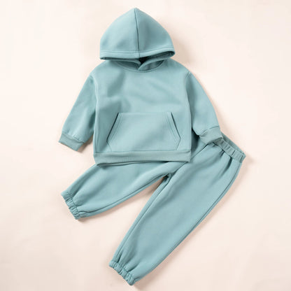 Baby in a pink hooded tracksuit, adorable and warm winter wear for toddlers