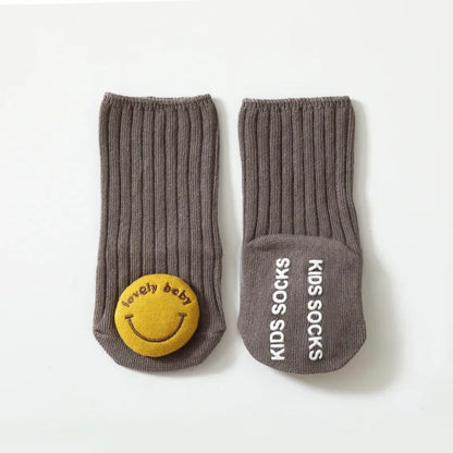Display of multiple pairs of non-slip cotton baby socks in various cartoon patterns, great for toddler apparel.