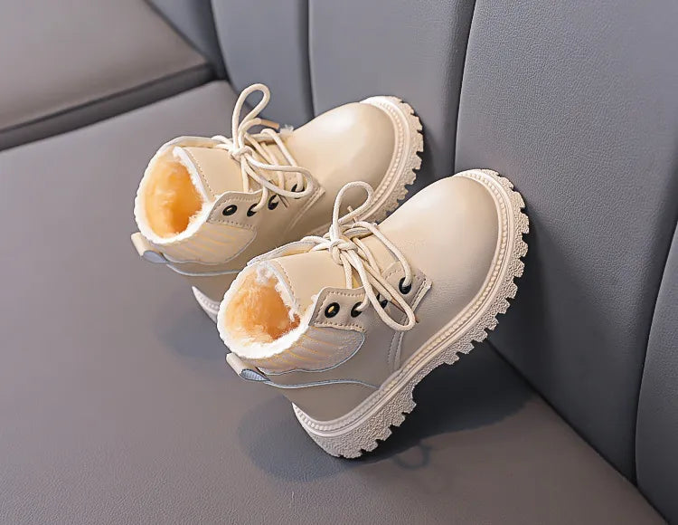 Anti-skid sole detail on a pair of kids plush winter boots, profile view