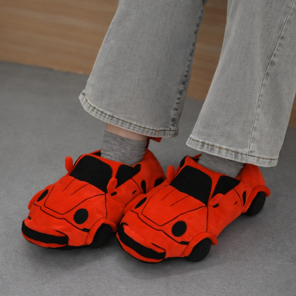 Close-up of a red racing car slipper with black wheels, warm plush material for kids
