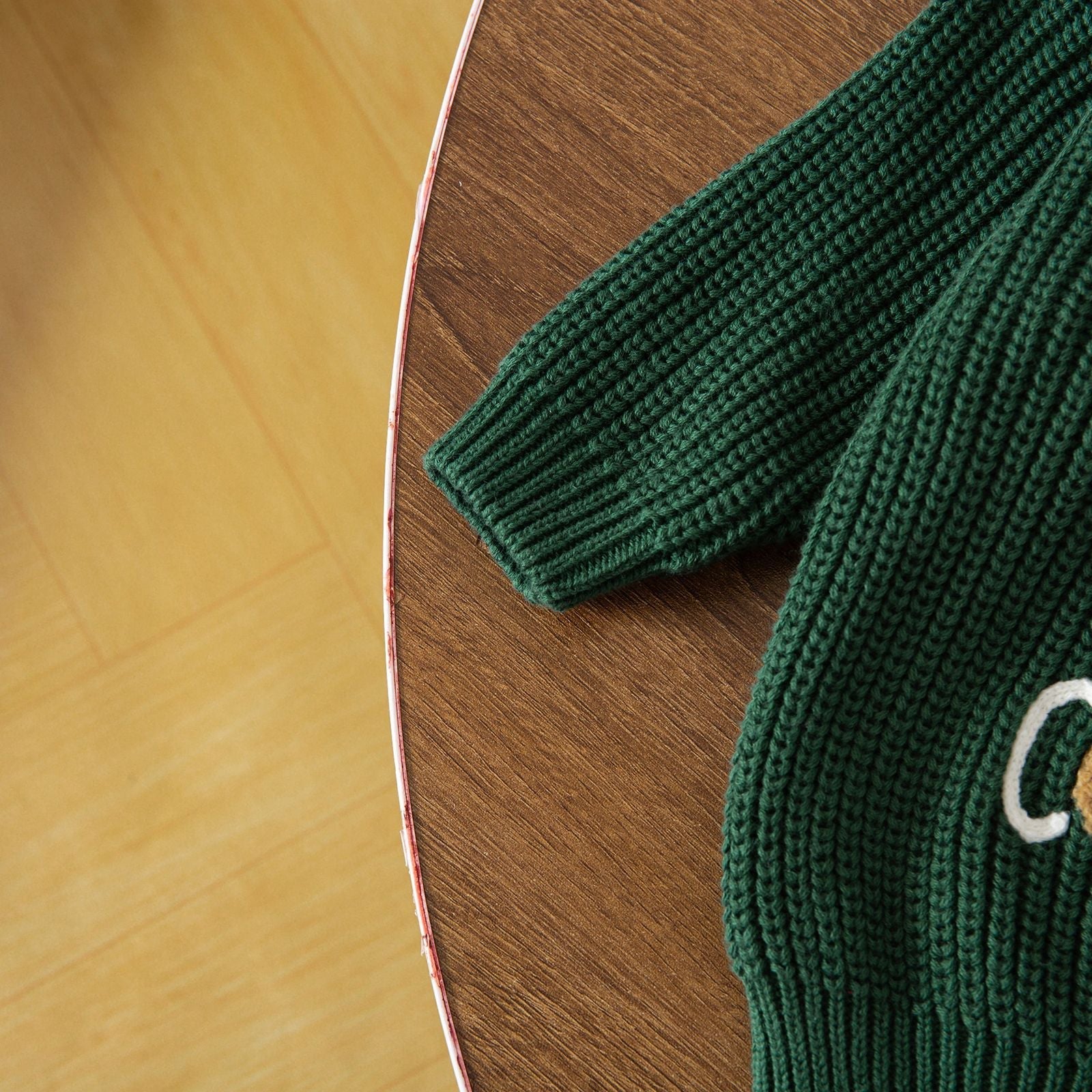 Soft cotton baby Christmas sweater, cream color with a small festive tree embroidery.