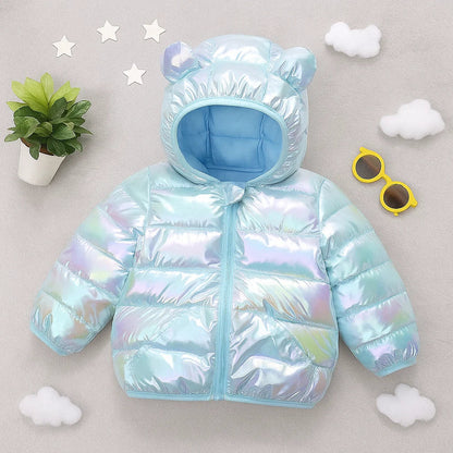 Happy child wearing a blue padded winter jacket with bear hood, playing outdoors