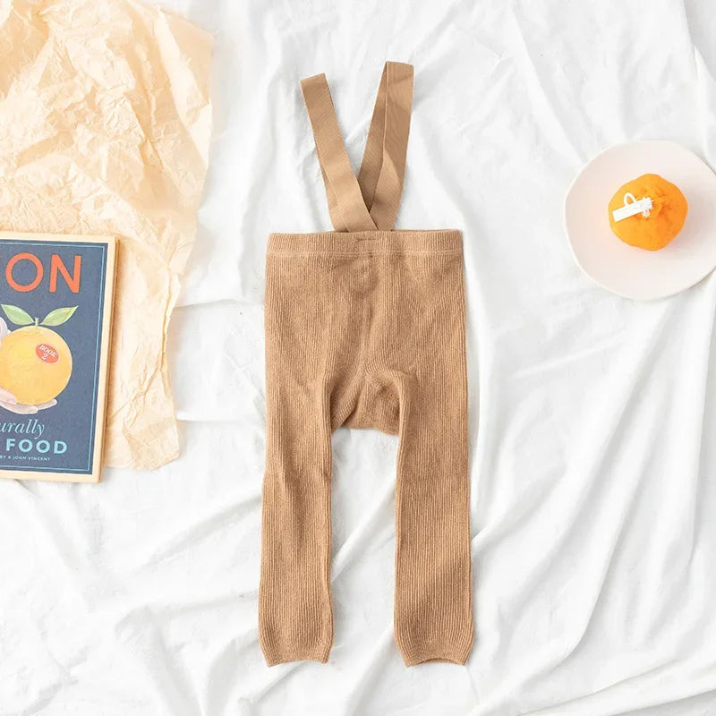Detail of the soft fabric texture of kids' cotton leggings with attached suspenders