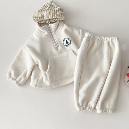 Child playing in a cozy gray knit sweater and pants, perfect for winter comfort.