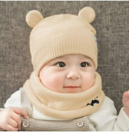 Close-up of pink knitted baby hat and scarf set, showing soft plush lining detail for warmth