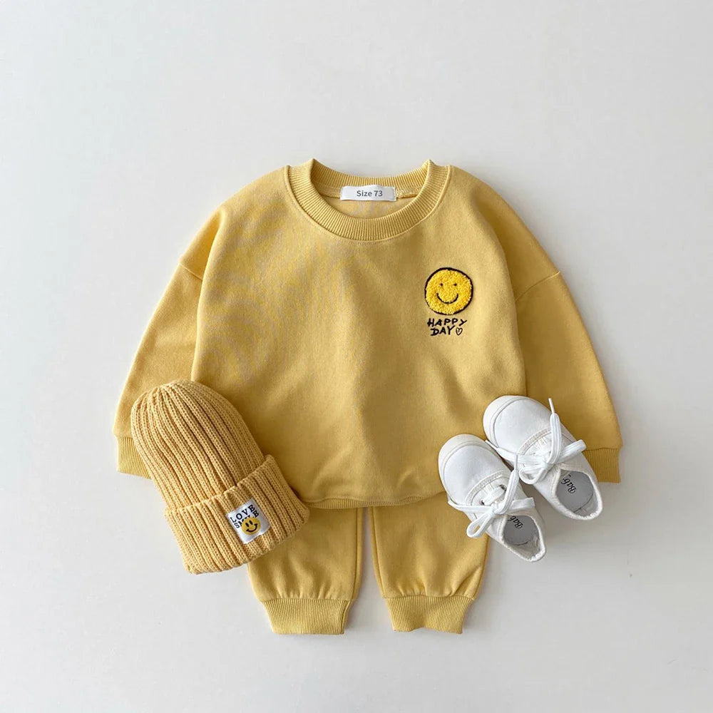 Unisex baby clothing: cozy cotton hoodie and pant set featuring a cute smiley face design