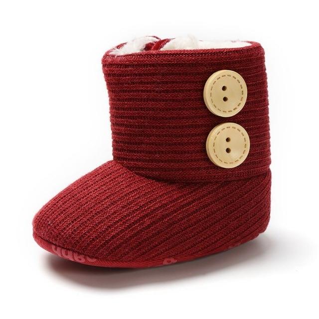 Assortment of unisex knitted baby boots in various neutral colors, soft and warm design.