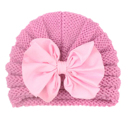 Side view of a toddler in a chunky knitted candy color baby hat, cute winter style