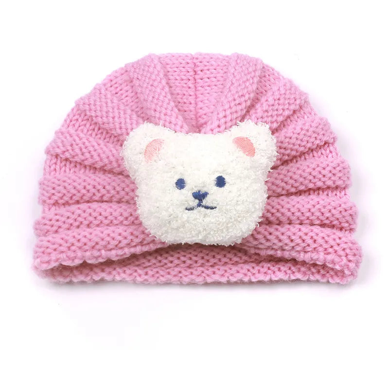 Baby hands reaching for a cozy knitted candy color beanie, soft winter headwear