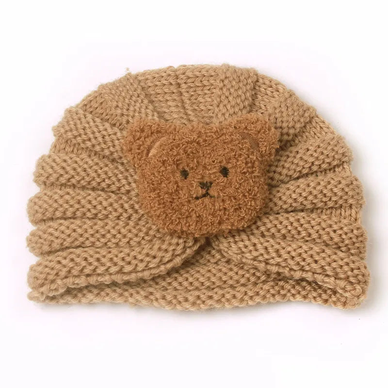Infant model showcasing a stylish knitted candy color baby beanie, fashionable winter hat